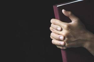 im Gebet gefaltete Hände auf einer heiligen Bibel im Kirchenkonzept für Glauben, Spiritualität und Religion, Anbetung, Sünden und Gebet.