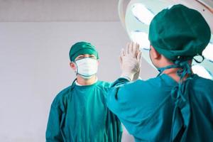 Professionelle Ärzte, die Operationen durchführen. Ärzteteam gibt High Five, Erfolgs- und Teamwork-Konzepte foto