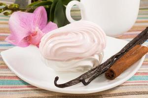 rosa Marshmallow auf einer Untertasse mit Vanille, Zimt foto