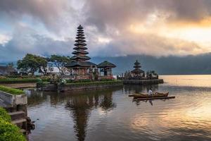 alter Pura-Ulun-Danu-Bratan-Tempel mit Touristenpaddel und Sonnenaufgangshimmel foto