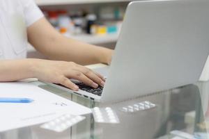 Apotheker mit Laptop-Computer und Medikamenten in der Apotheke foto