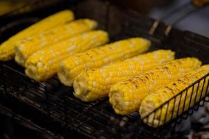 gegrillter Mais. Streetfood-Festival. Nahaufnahme von appetitlich gegrilltem Zuckermais auf dem Grill foto