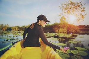 Frau, die Seekajak in der Lotusblumenlagune segelt foto