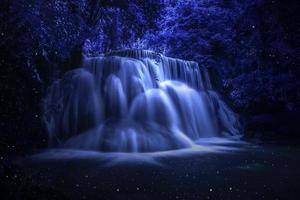 schöne wasserfallnaturlandschaft von bunt in einem tiefen tropischen fantasiedschungel der nacht foto