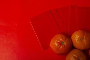 chinesisches neujahrskonzept - mandarinen und rotes paket foto
