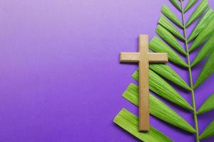 Kreuz und Palmblätter auf lila Hintergrund. Konzept der Fastenzeit. foto