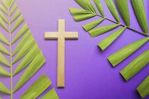Kreuz und Palmblätter auf lila Hintergrund. Konzept der Fastenzeit. foto