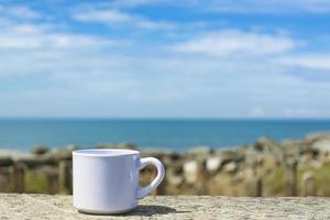 leere weiße tasse auf unscharfem strandhintergrund foto