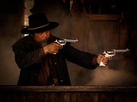 westliche Cowboys kämpfen mit Waffen, um sich in der Taverne zu schützen, auf dem Land, das das Gesetz noch nicht erreicht hat foto