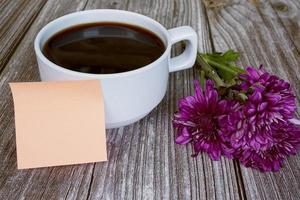 Haftnotiz mit weißer Kaffeetasse und Blumen. Platz kopieren. foto