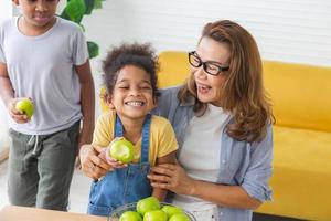 Kinder und Großmutter genießen mit rohem Bio-Grünapfel, Kinder und reife Frauen, die grüne Äpfel mit einem Lächeln beißen foto