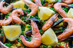Schließen Sie klassische Paella mit Meeresfrüchten mit Muscheln, Garnelen und Gemüse foto