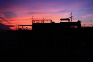 schöner bunter sonnenuntergang mit silhouette von stadtgebäuden. foto