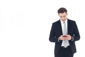 Gutaussehender Geschäftsmann in Anzughand, der Smartphone isoliert auf weißem Hintergrund hält. Kopierraum foto