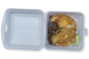 Hackfleisch mit Basilikum und Omelette in Schaumbox. verzehrfertige Plastiklöffel. für eine schnelle Mahlzeit. auf lokalisiertem weißem Hintergrund mit Beschneidungspfad. foto