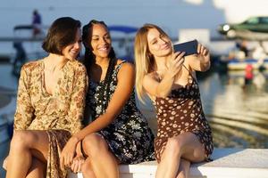 inhalt verschiedene freundinnen, die selfie am pier machen foto