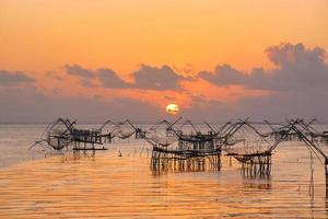 Sonnenaufgang und riesige quadratische Kescher zum Fangen von Fischen foto
