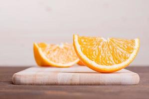 geschnittene reife appetitliche köstliche Orange auf Schneidebrett braun foto