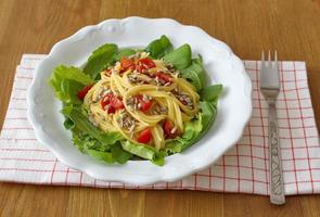 Ein gesundes Mittagessen besteht aus Maisspaghetti, Salat, Samen und Tomaten foto
