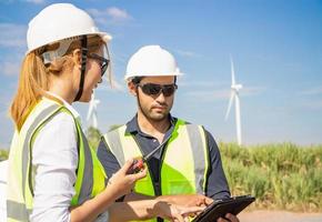 ingenieurteam, das im windturbinenpark arbeitet. erneuerbare energie mit windgenerator durch alternatives energiekonzept. foto