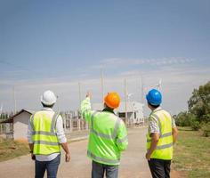 ingenieurteam, das im windturbinenpark arbeitet. erneuerbare energie mit windgenerator durch alternatives energiekonzept. foto