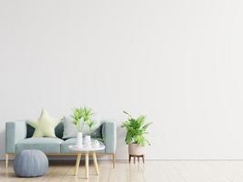 leeres wohnzimmer mit blauem sofa, pflanzen und tisch auf leerem weißem wandhintergrund. foto