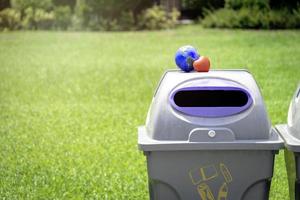 erde mit rotem herz auf dem papierkorb im park, rette die welt, liebe und schütze unseren planeten und umweltfreundliches konzept foto