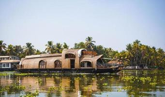 hausboot vergnügungskreuzfahrtschiff in indien, kerala auf den mit algen bedeckten flusskanälen von allapuzha in indien. Boot auf dem See in der hellen Sonne und Palmen inmitten der Tropen. Hausboot sehen foto