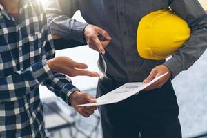 Architekt und Ingenieur treffen Planung für ein neues Projekt mit Baumaschinen auf dem Tisch, Architekt und Ingenieur arbeiten mit Blaupause. foto