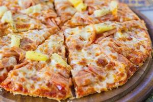 hawaiianische pizza ist ein italienisches essen, das aus tomatensauce, gehackter ananas, schinken und käse zubereitet wird.