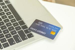 E-Commerce, Online-Shopping und Technologiekonzept. Nahaufnahme einer gefälschten Kreditkarte auf einem Laptop auf einem weißen Schreibtisch. foto