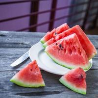 Wassermelonenscheiben auf einem Teller auf einem hölzernen Hintergrund foto