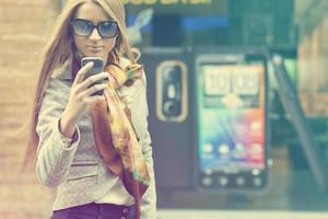 Frau auf der Straße mit Smartphone foto