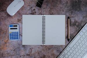 Laptop, Smartphone und Zubehör auf einem schwarzen Schreibtisch. computerwerkzeuge auf einem schreibtisch im büro, draufsicht mit kopierraum, flach liegend. foto