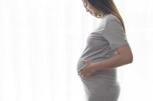 junge schöne schwangere frau zu hause, mutterschafts- und schwangerschaftspflegekonzept foto