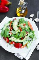 gesunder Avocadosalat mit Spinat, Zwiebeln, Gurken und Tomaten foto