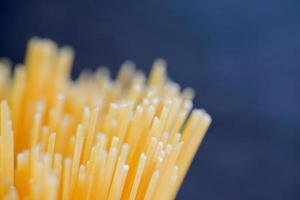 gelbe lange Spaghetti auf rustikalem Hintergrund. gelbe italienische Pasta. lange Spaghetti. rohe Spaghetti Bolognese. rohe Spaghetti. Essen Hintergrund Konzept. italienisches Essen und Menükonzept. foto