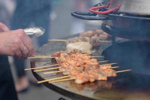 Garnelen kochen, Garnelenspieße auf dem Grill beim Street Food Festival - Nahaufnahme foto