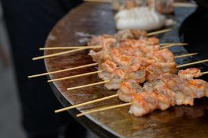 Garnelen kochen, Garnelenspieße auf dem Grill beim Street Food Festival - Nahaufnahme foto