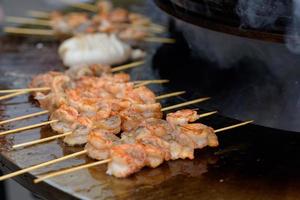 Garnelen kochen, Garnelenspieße auf dem Grill beim Street Food Festival - Nahaufnahme foto