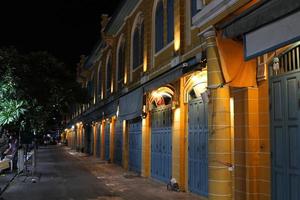 Gelbes einheimisches Retro-Gebäude in Bangkok bei Nacht und Fußweg, Gebäude im europäischen Stil. foto