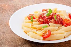 Penne-Nudeln mit Bolognese-Sauce, Parmesan und Basilikum foto