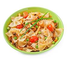 Farfalle-Nudeln mit Meeresfrüchten, Kirschtomaten und grünen Erbsen foto