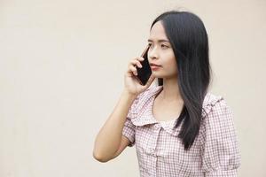 asiatische frau, die am telefon über geschäfte spricht foto