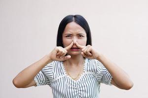 asiatische Frauen bedecken ihre Nasen mit ihren Händen, weil sie schlecht riechen. foto