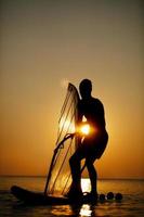 Mann beim Sonnenuntergang segeln foto