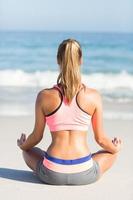 Fit Frau macht Yoga am Meer