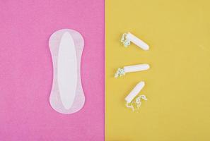 Hygienepflege an kritischen Tagen. die Wahl zwischen einem Tampon und einer Damenbinde. Menstruationszyklus. Hygieneprodukte für Frauen. Ansicht von oben foto