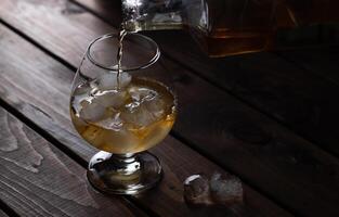 Alkohol wird in einem Makroglas auf Eis gegossen foto