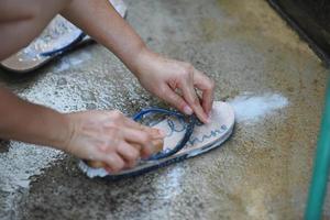 Reinigen Sie die Schuhe mit Wasser von Hand. foto